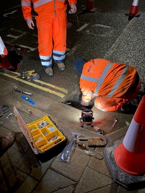 People installing a device in a drain