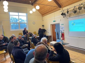 Group of people in a village hall with a powerpoint presentation
