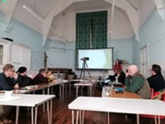Person giving a presentation to a group a parish councillors sitting round tables