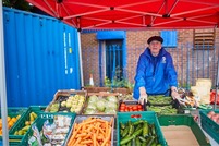 Elderly gentleman stood at a veg market stall