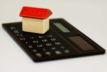 Small model wooden house on a calculator