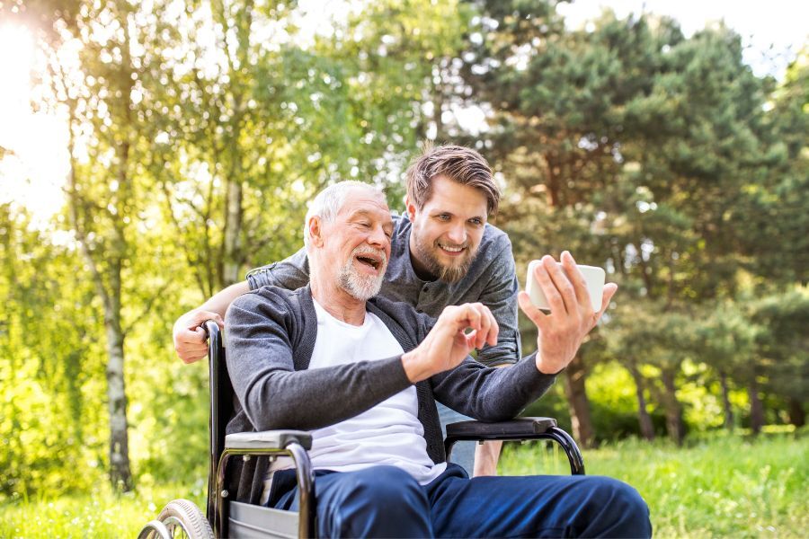 Young man caring for older man in wheelchair