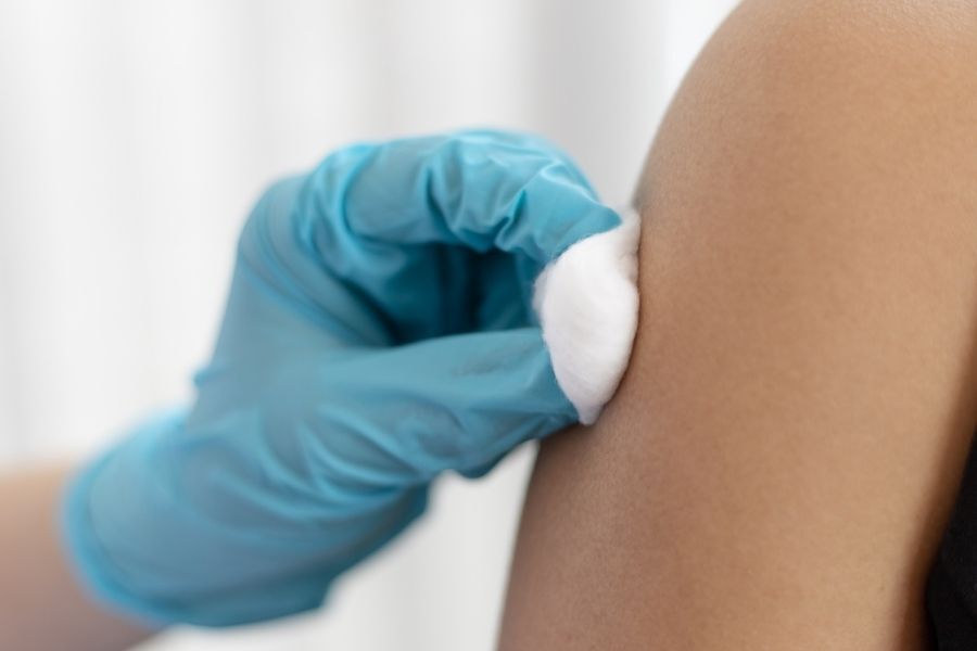 A person receiving their vaccination in their upper arm