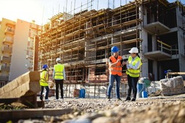 construction works in high vis jackets look at a building site