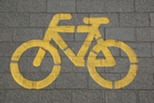 A bike sign painted on paving