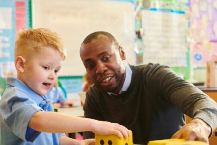 A young child and a teacher in a classroom