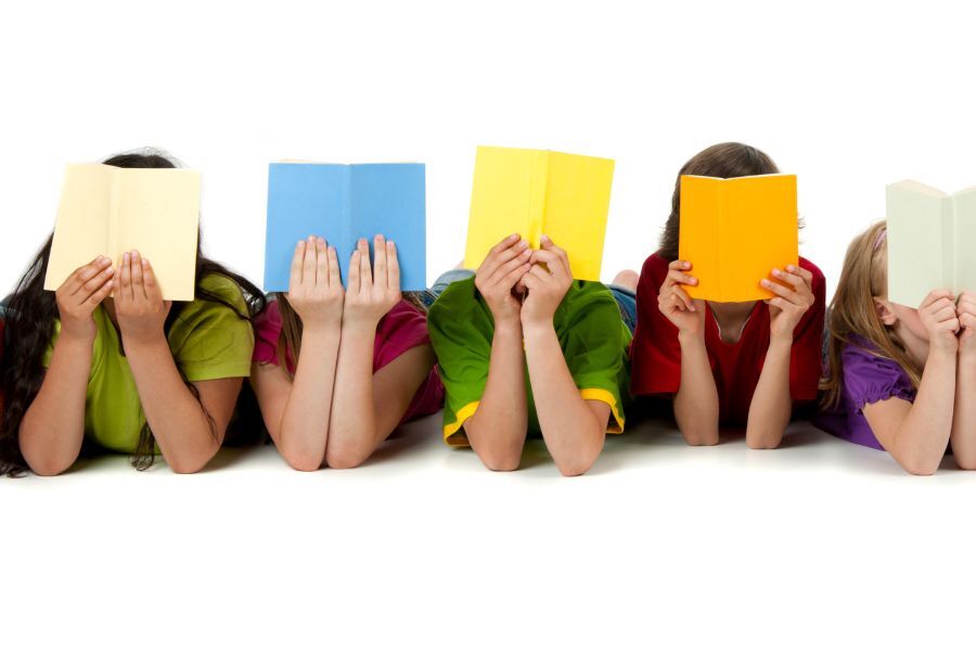 A line of children lying on the floor with their reading books in front of their faces