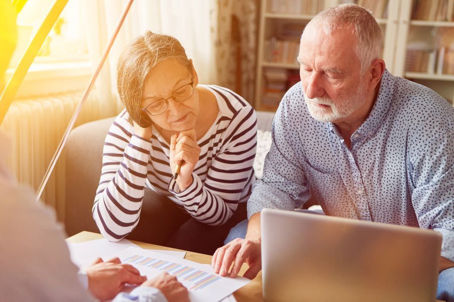 An elderly couple looking at information on their laptop