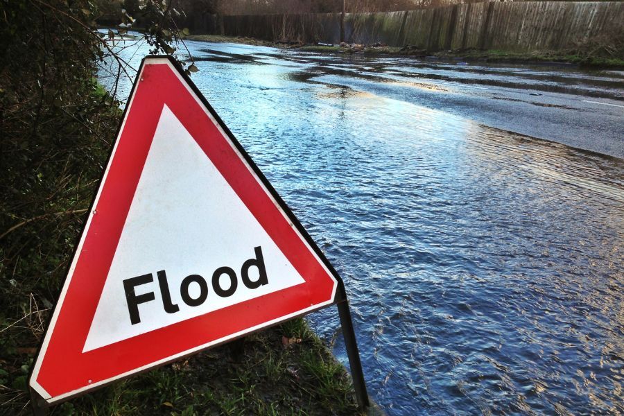 Flood sign on side of flooded road