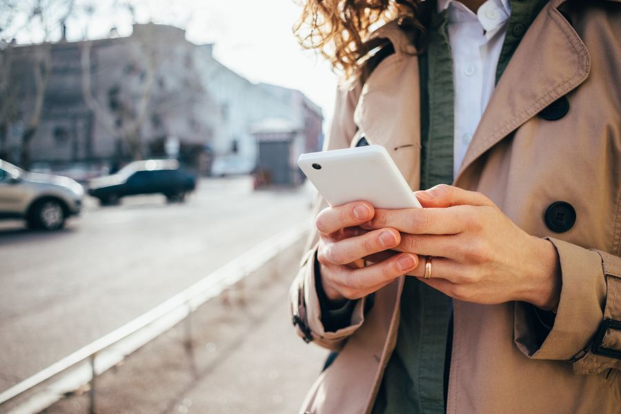 Woman wearing coat outside using mobile phone