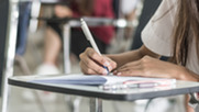 Pupil completing a test paper whilst sat at a desk