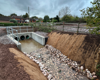 River flowing into a new culvert, with steep banks either side