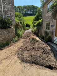 Mud piled up in a street surrounded by houses after flooding