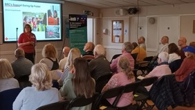 person standing doing presentation at the front of a room