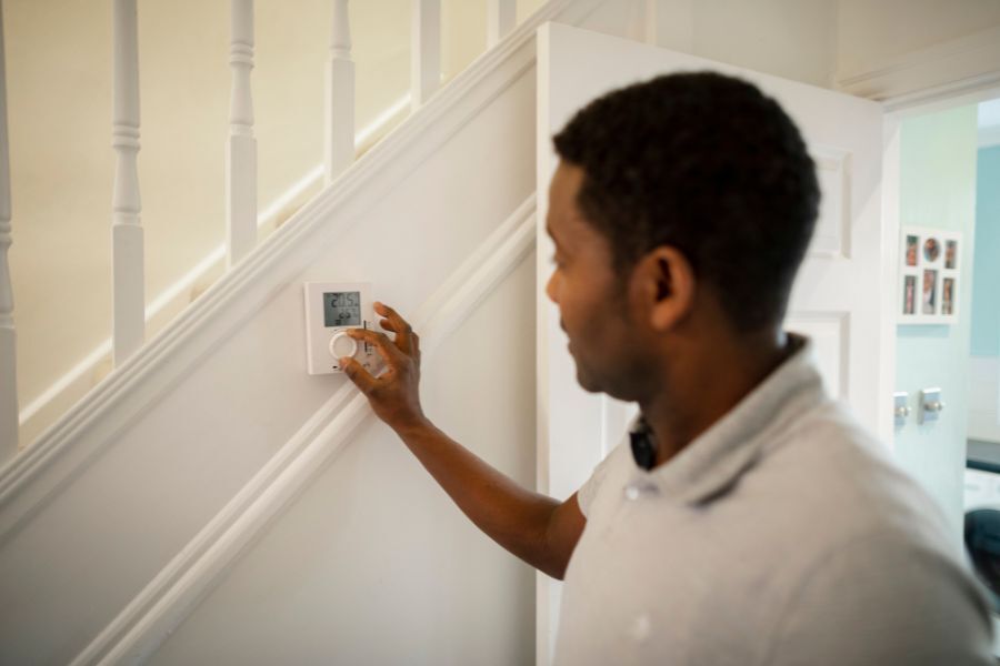 Man adjusting thermostat