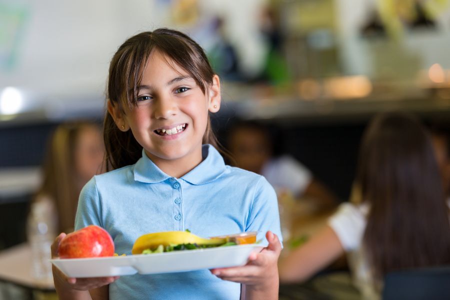 Girl with school lunch on a tray