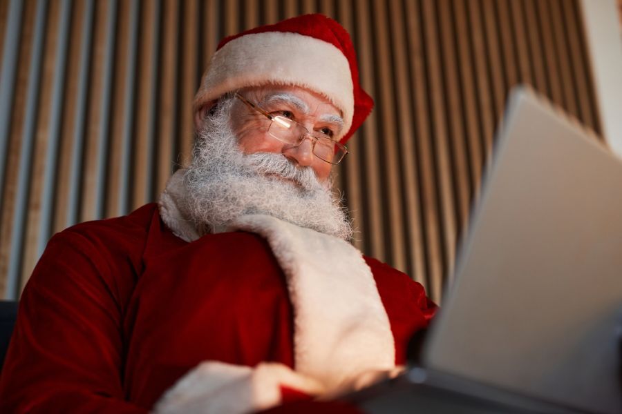 Father Christmas on a laptop reading