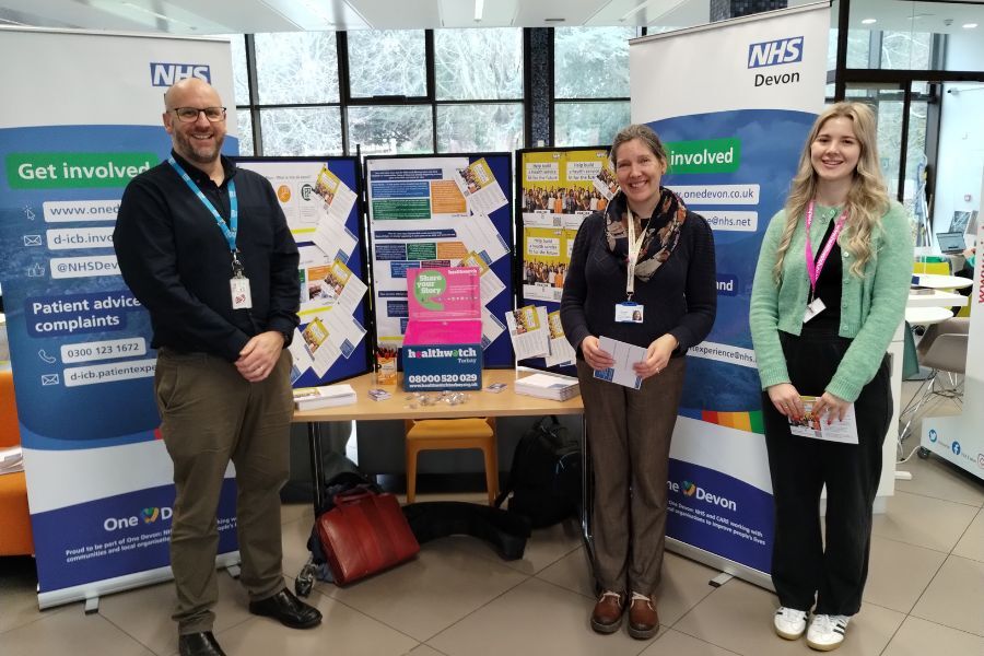 NHS Devon staff stood in front of some presentation boards, ready to speak to people about the NHS 10 year plan
