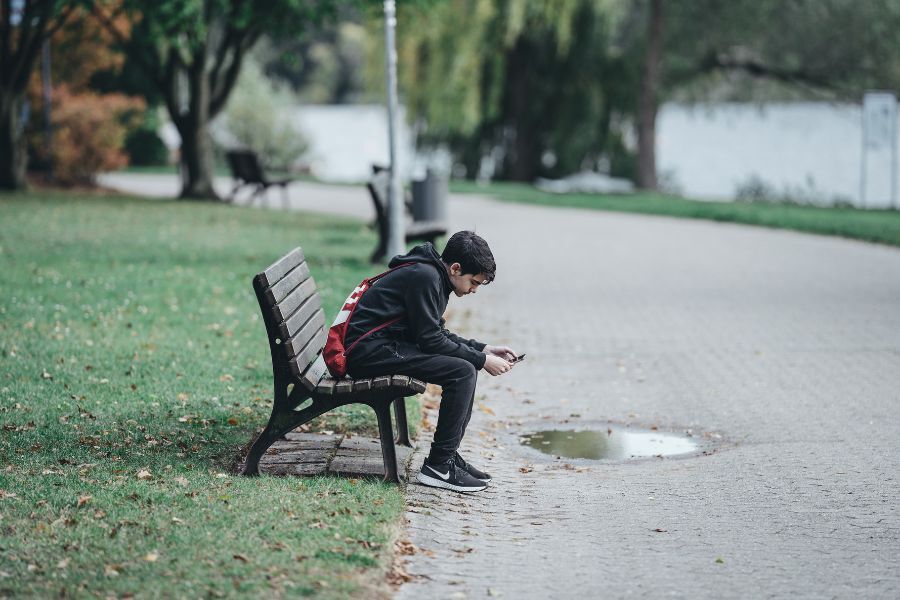 Teenage boy sat on bench