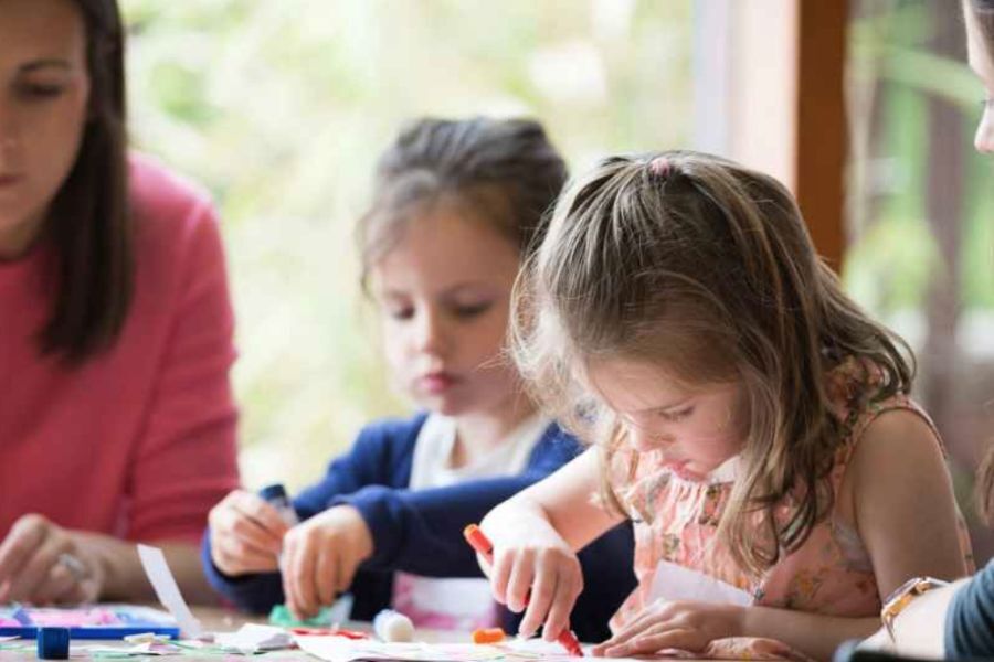 Easter activities - young people sat around a table in a libraries drawing