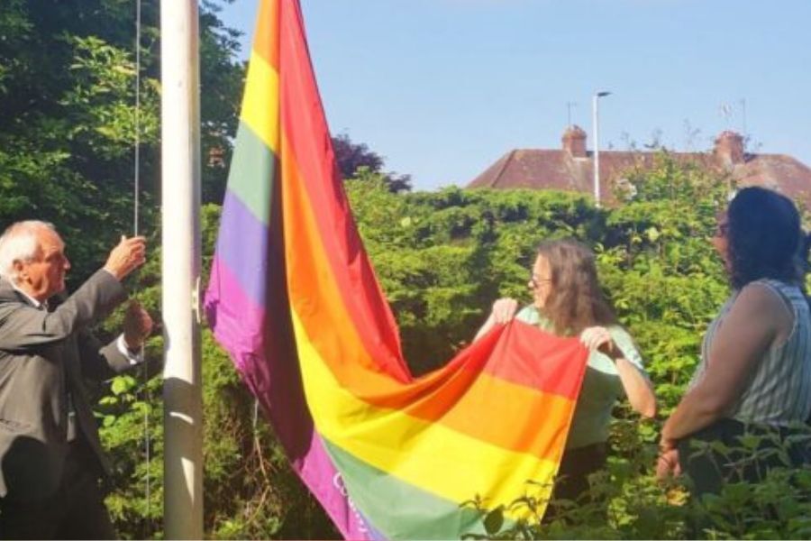 The Chairman of Devon County Council, Cllr John Hart, raising the LGNTQ+ flag at County Hall to mark Exeter Pride