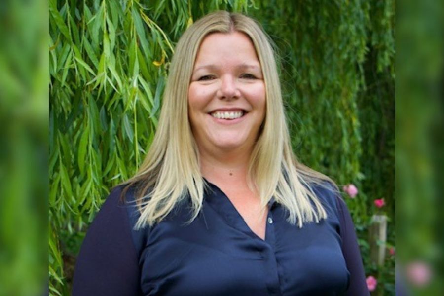 Carolyne Hague, Principal OT at Devon County Council stood outside, in front of a tree, smiling at the camera.