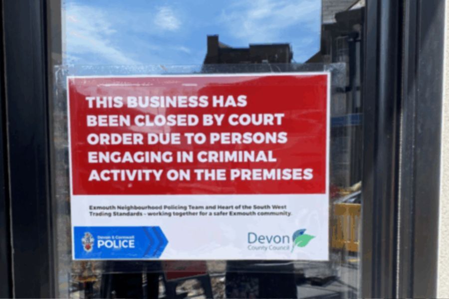 Sign on shop window reads This business has been closed by court order due to persons engaging in criminal activity on these premises