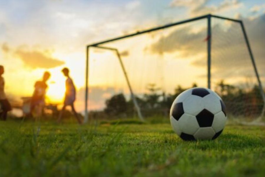 boys playing football in late afternoon sun