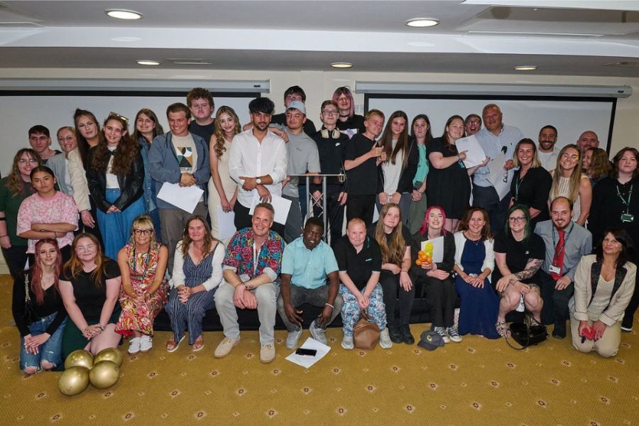 A group photo of lots of young people smiling looking at the camera