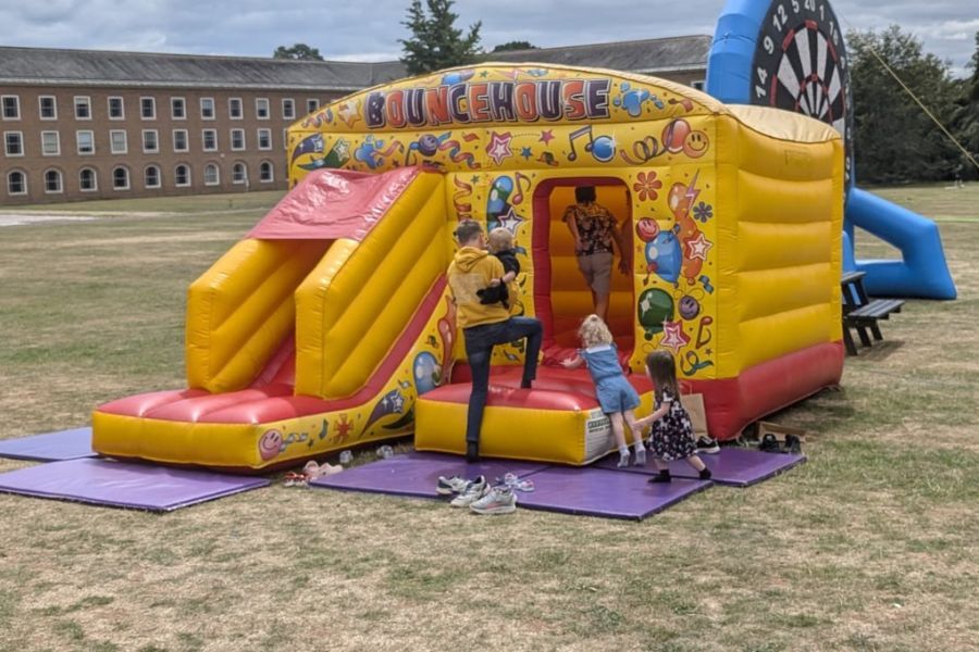 Bouncy castle in the grounds at County Hall. Photo shows a foster carer and two unidentifiable young children playing on the bouncy castle