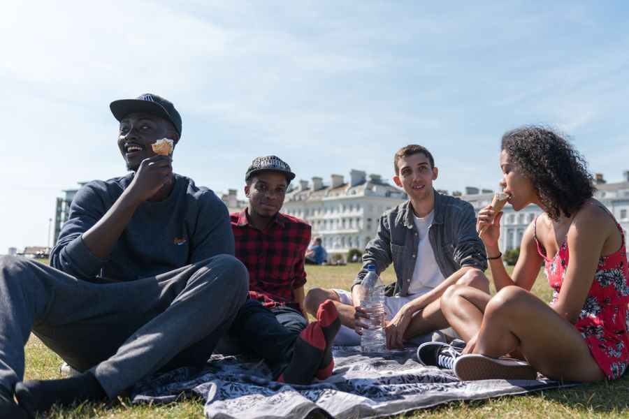 Young people sitting on grass eating icecream