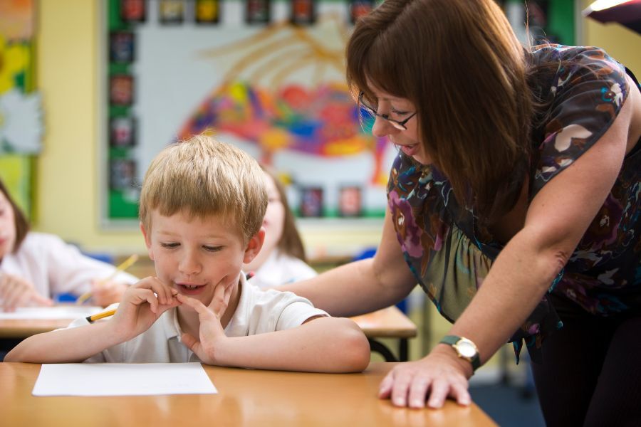 Adult supporting child at school