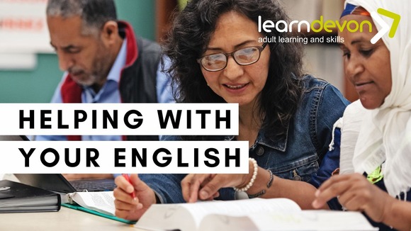 Three adults students in a classroom looking at books
