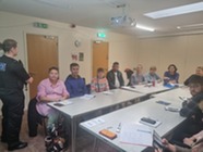 Police officer talking to adult students in a classroom