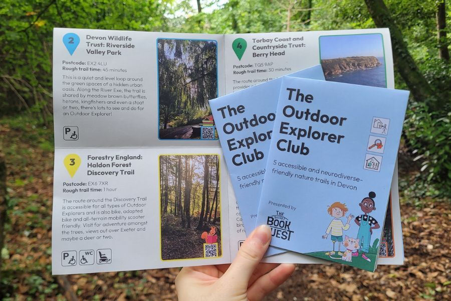 Hands holding The Outdoor Explorers Club leaflet