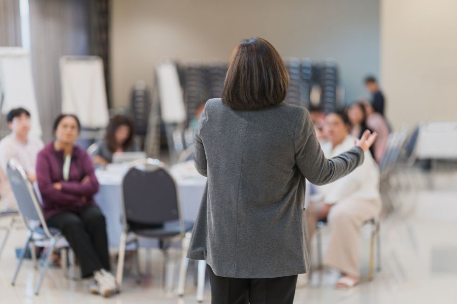 A workshop session with lead person addressing a room of other people