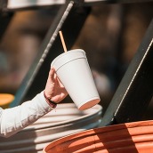 paper and plastic cup going into a bin