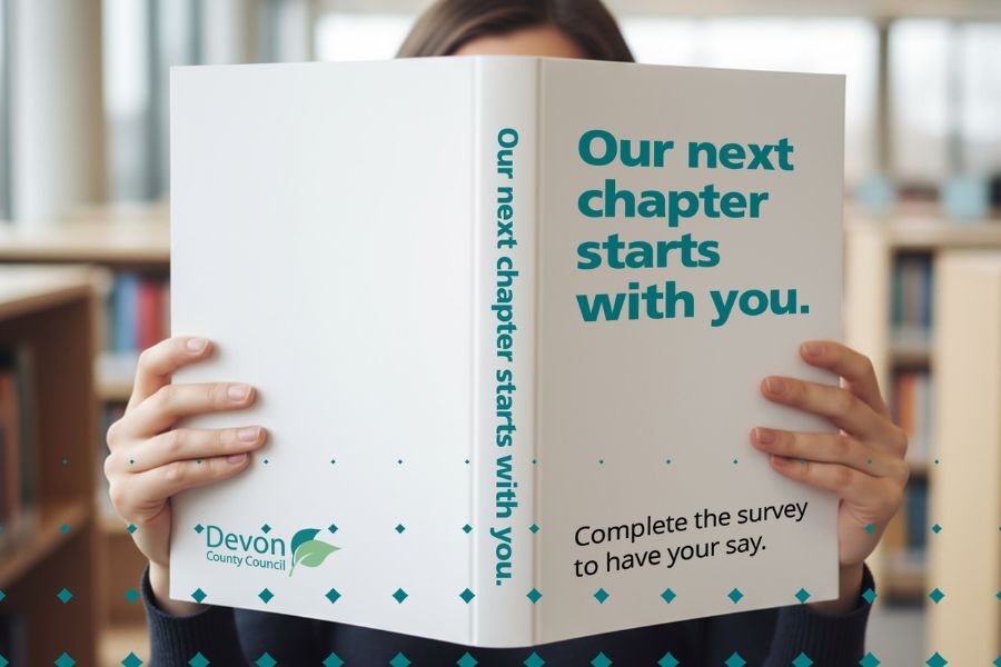 A person holding a book up in front of their face. Title of the book reads 'our next chapter starts with you'