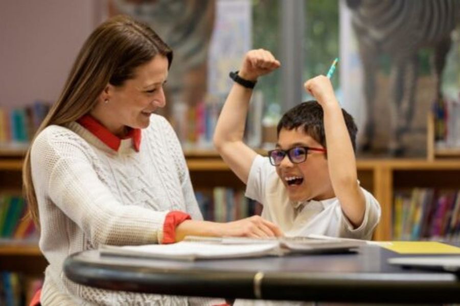 A young pupil and his teacher giving one to one support in class