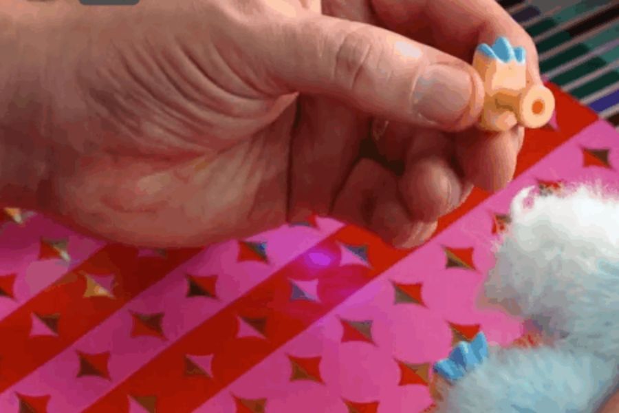 A close up photograph of a person's hand holding a toy