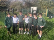 Young, smiling school children standing in a line on their school field.