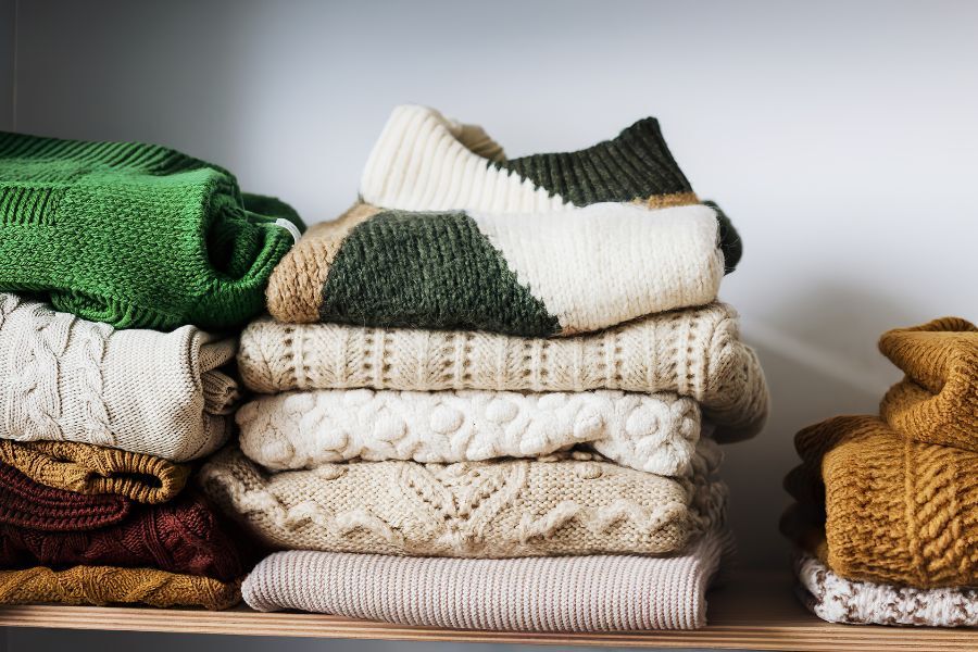 A shelf of folded warm woolly jumpers