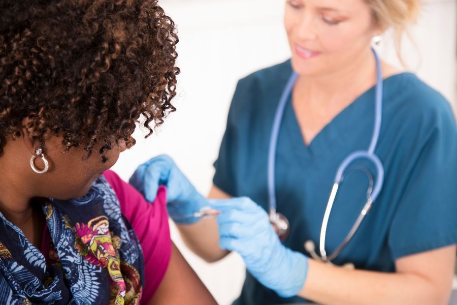 Woman recieving a vaccination from a healthcare professional 