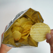 from British Heart Foundation. Hands eating a pack of crisps