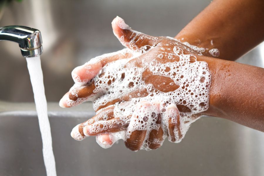 Hands being washed with soap under a tap of running water