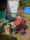 Man in wheelchair chopping wood