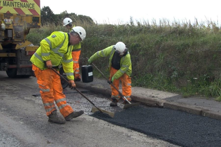 Road engineers working on resurfacing a road
