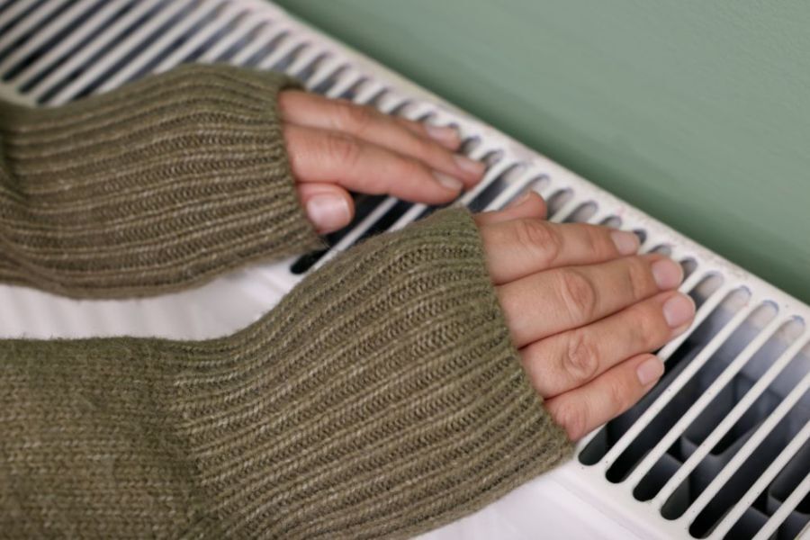 hands warming themselves on a radiator