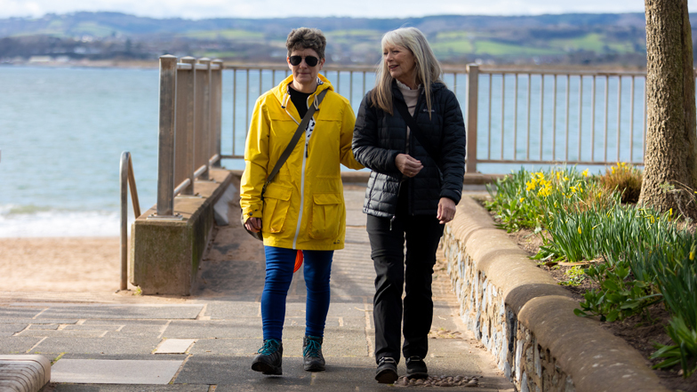 sighted guide walking along the coast