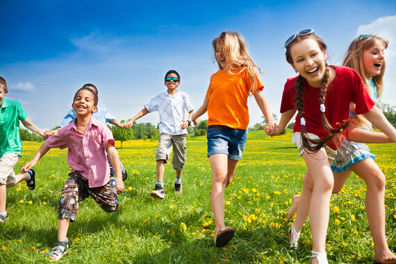 happy summer children running on grass in sunshine